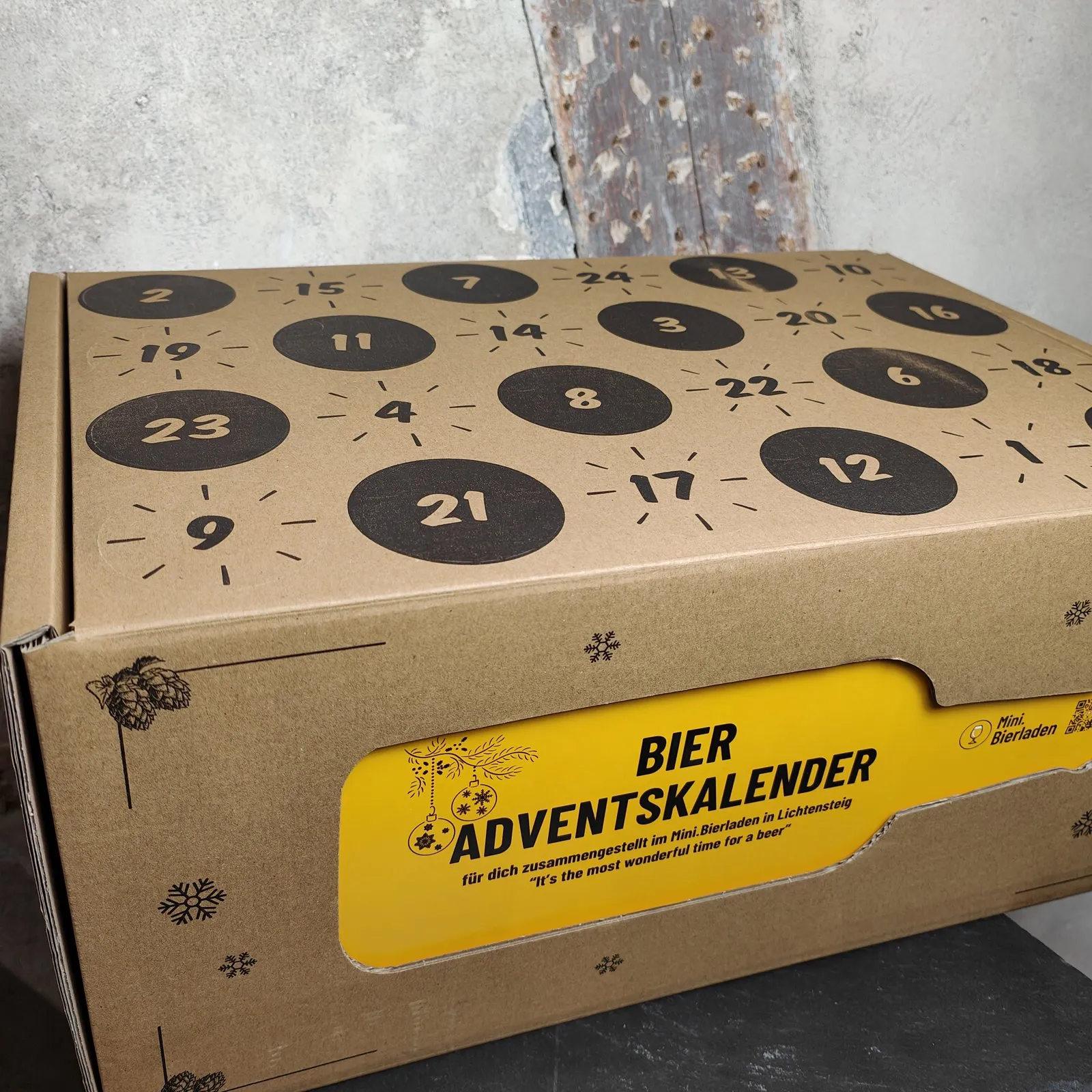 Bier-Adventskalender des Mini.Bierladens: Karton mit 24 nummerierten Türchen und gelbem Etikett